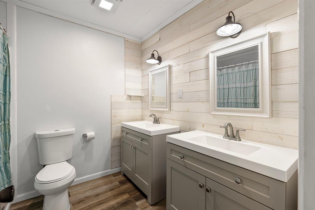 148 Royal Lane Commerce, TX 75428 - Photo 13 of 38 a bathroom with a toilet sink a mirror and vanity
