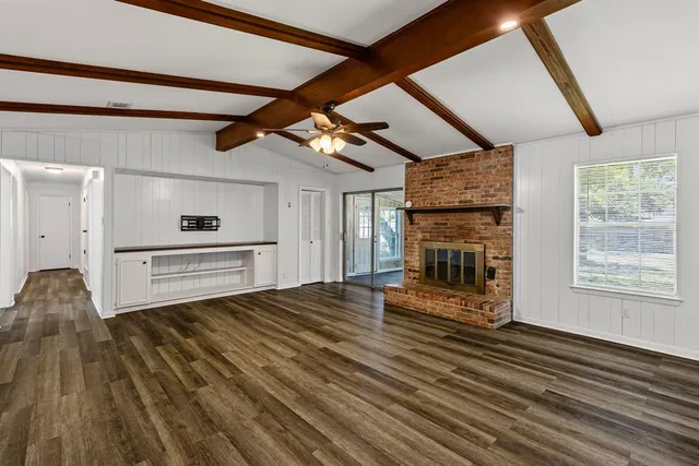 a view of a livingroom with wooden floor and a fireplace