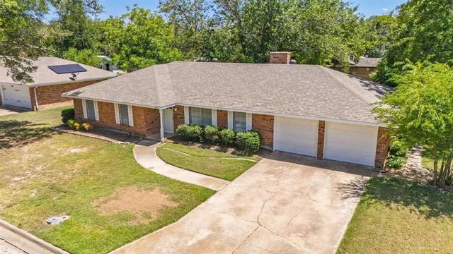 a view of a house with pool plants and a large tree