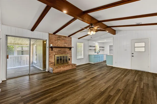 a view of empty room with wooden floor and fireplace