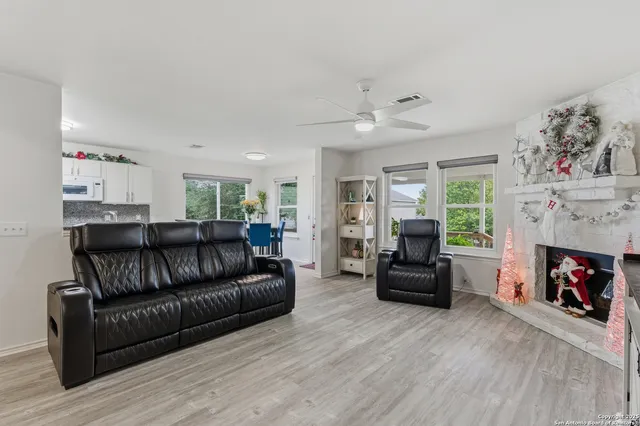 a living room with furniture a flat screen tv and a fireplace