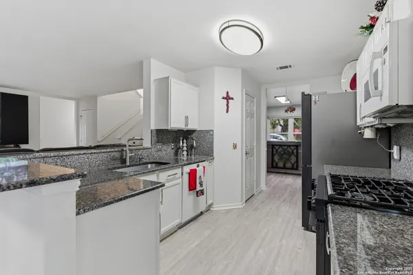 a kitchen with a sink a stove and cabinets
