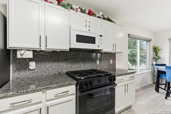 a kitchen with granite countertop cabinets stainless steel appliances and a sink