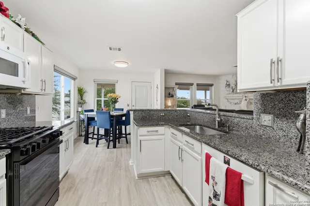 a kitchen with stainless steel appliances granite countertop sink stove top oven and cabinets