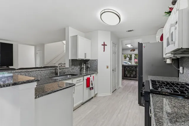 a kitchen with a sink a stove and cabinets