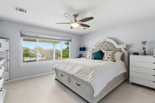 a bedroom with a large bed and a chandelier