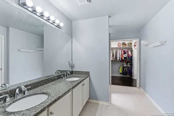 a bathroom with a granite countertop sink a mirror and shower