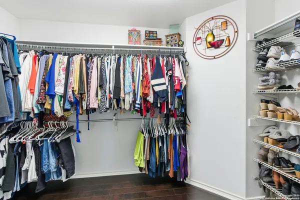 a view of walk in closet with clothes and shoes