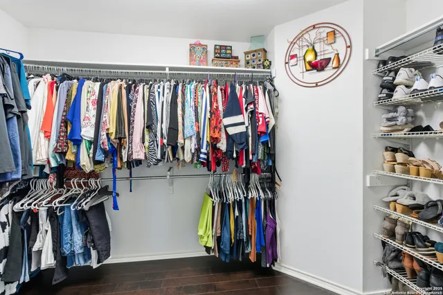 a view of walk in closet with clothes and shoes