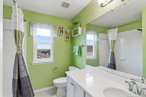 a bathroom with a sink a toilet and a mirror