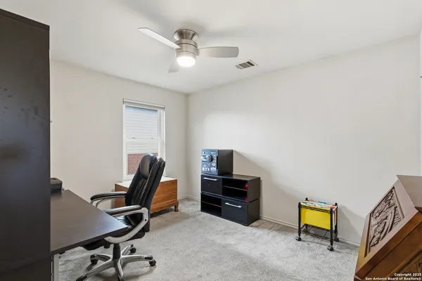 a view of a workspace with furniture and a window