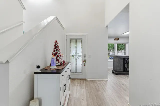 a view of a hallway to room with wooden floor and windows