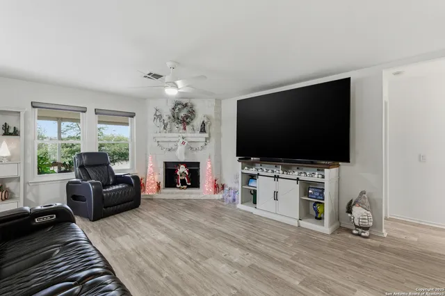 a living room with furniture a flat screen tv and a fireplace