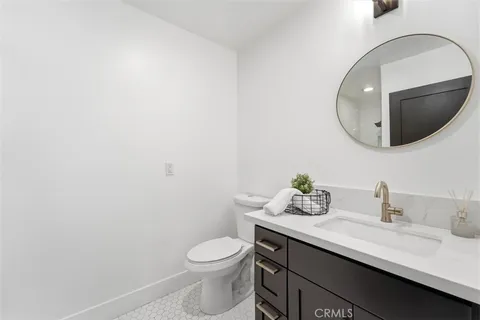 a bathroom with a granite countertop sink mirror and toilet