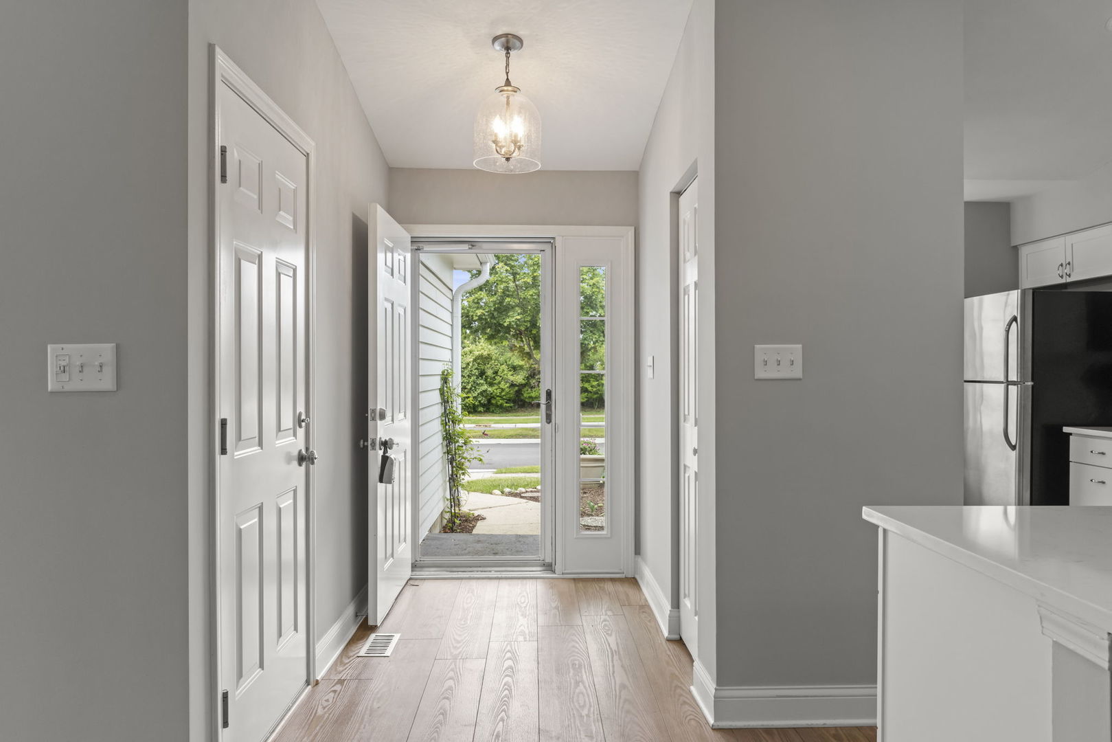 1802 77th Street Naperville, IL 60565 - Photo 4 of 29 a view of a hallway with wooden floor and a kitchen