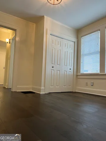 a view of a small space with wooden floor and a window