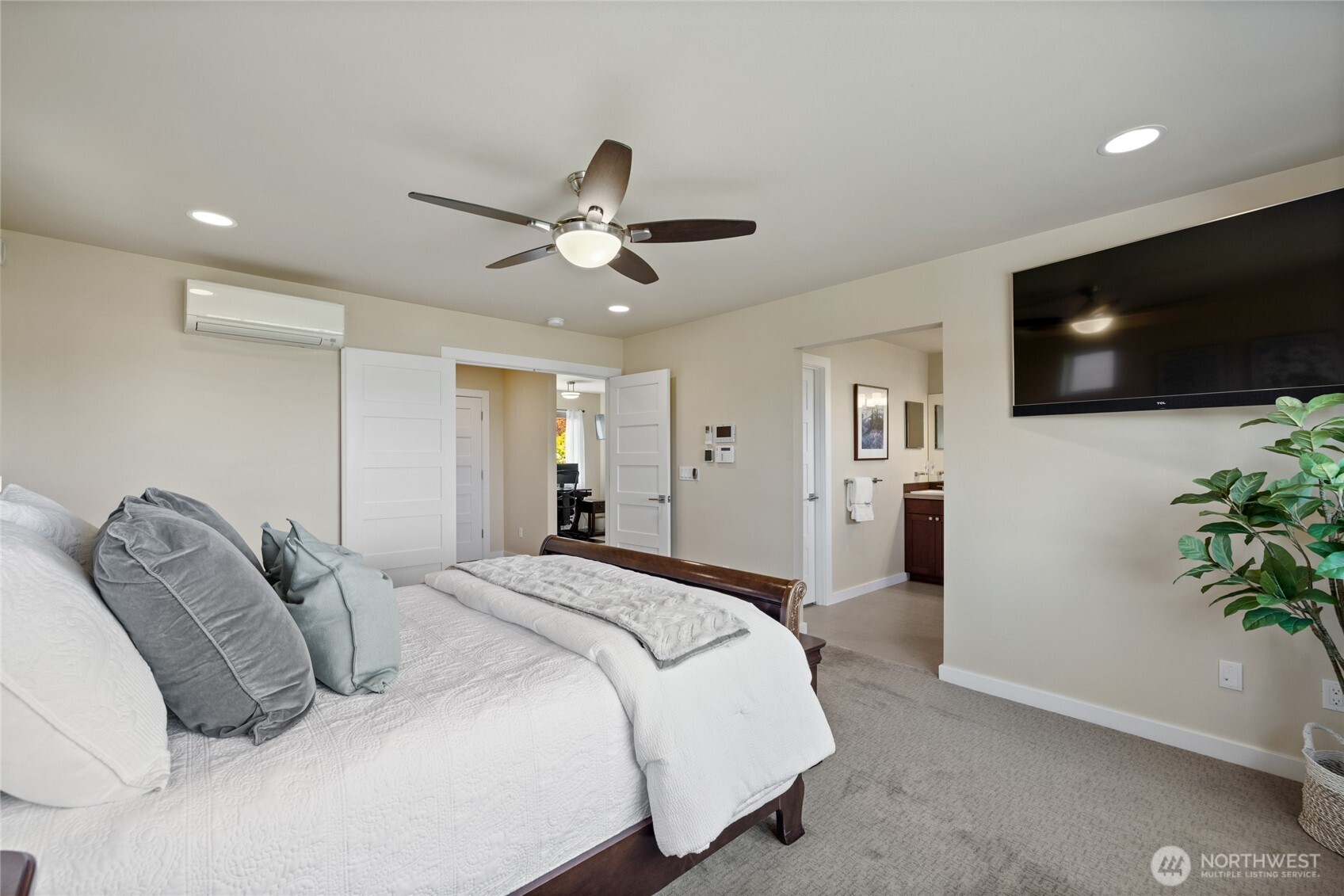 1409 Shattuck Avenue South Renton, WA 98055 - Photo 6 of 37 a spacious bedroom with a bed and a flat screen tv
