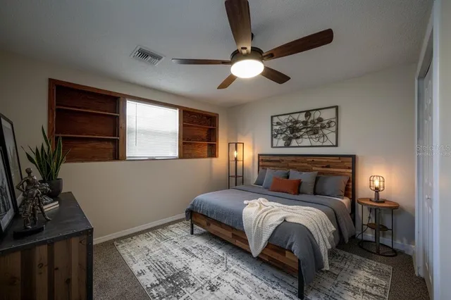 an empty room with a window and ceiling fan
