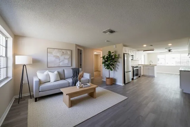 a living room with furniture and a wooden floor