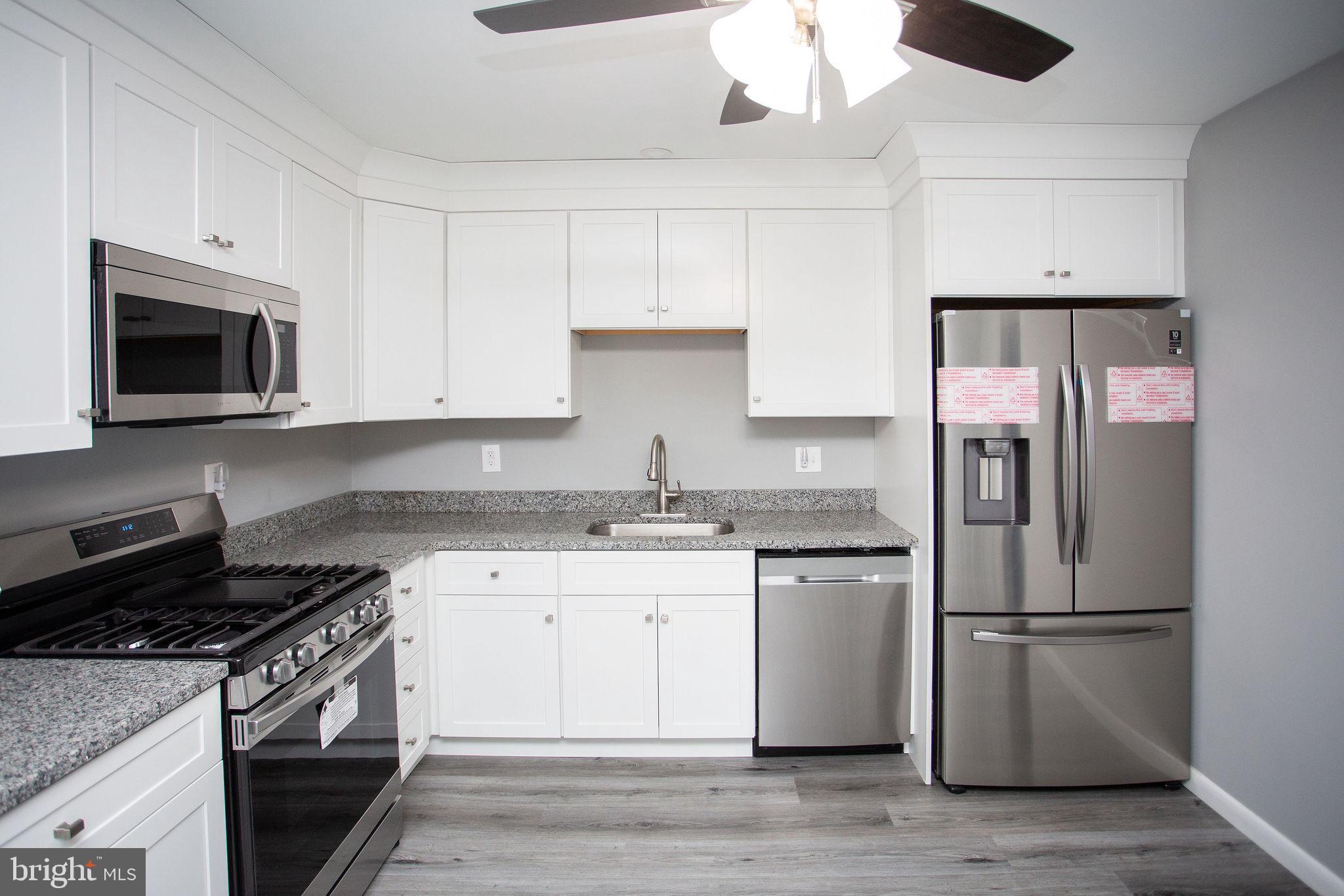 119 Trinity Avenue Blackwood, NJ 08012 - Photo 11 of 37 a kitchen with stainless steel appliances granite countertop a stove top oven a sink and a refrigerator