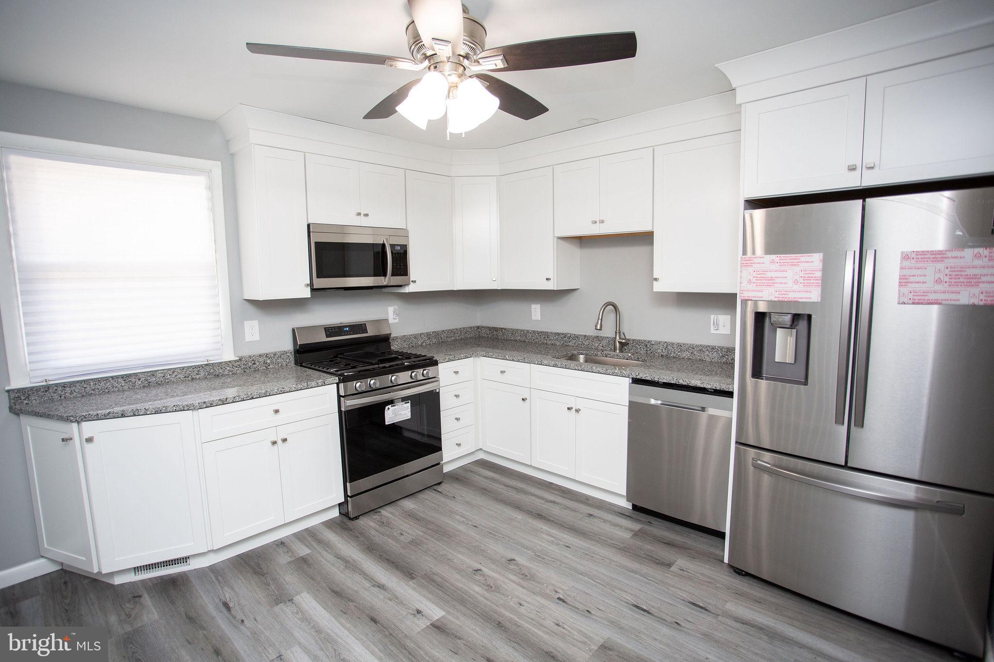 119 Trinity Avenue Blackwood, NJ 08012 - Photo 8 of 37 a kitchen with granite countertop a refrigerator oven a sink dishwasher and a stove with wooden floor