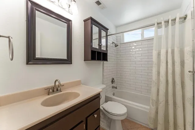 a bathroom with a sink toilet vanity and shower