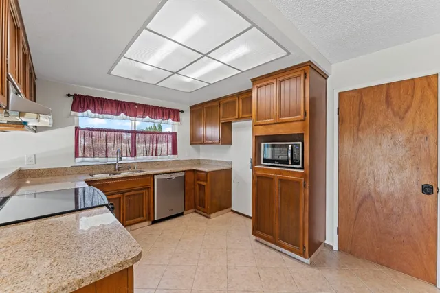a kitchen with stainless steel appliances granite countertop a stove a sink and a refrigerator