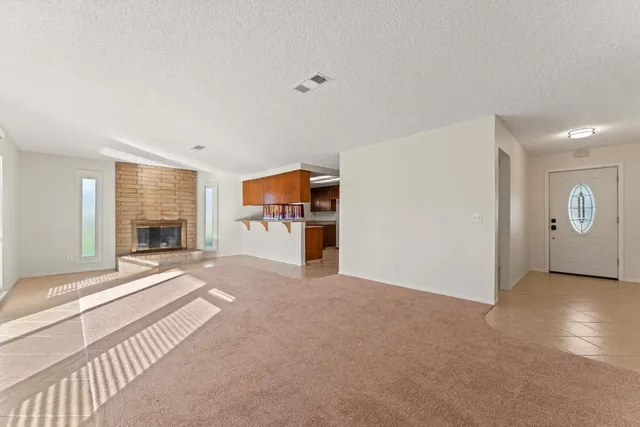 a view of an empty room with a fireplace and a large window