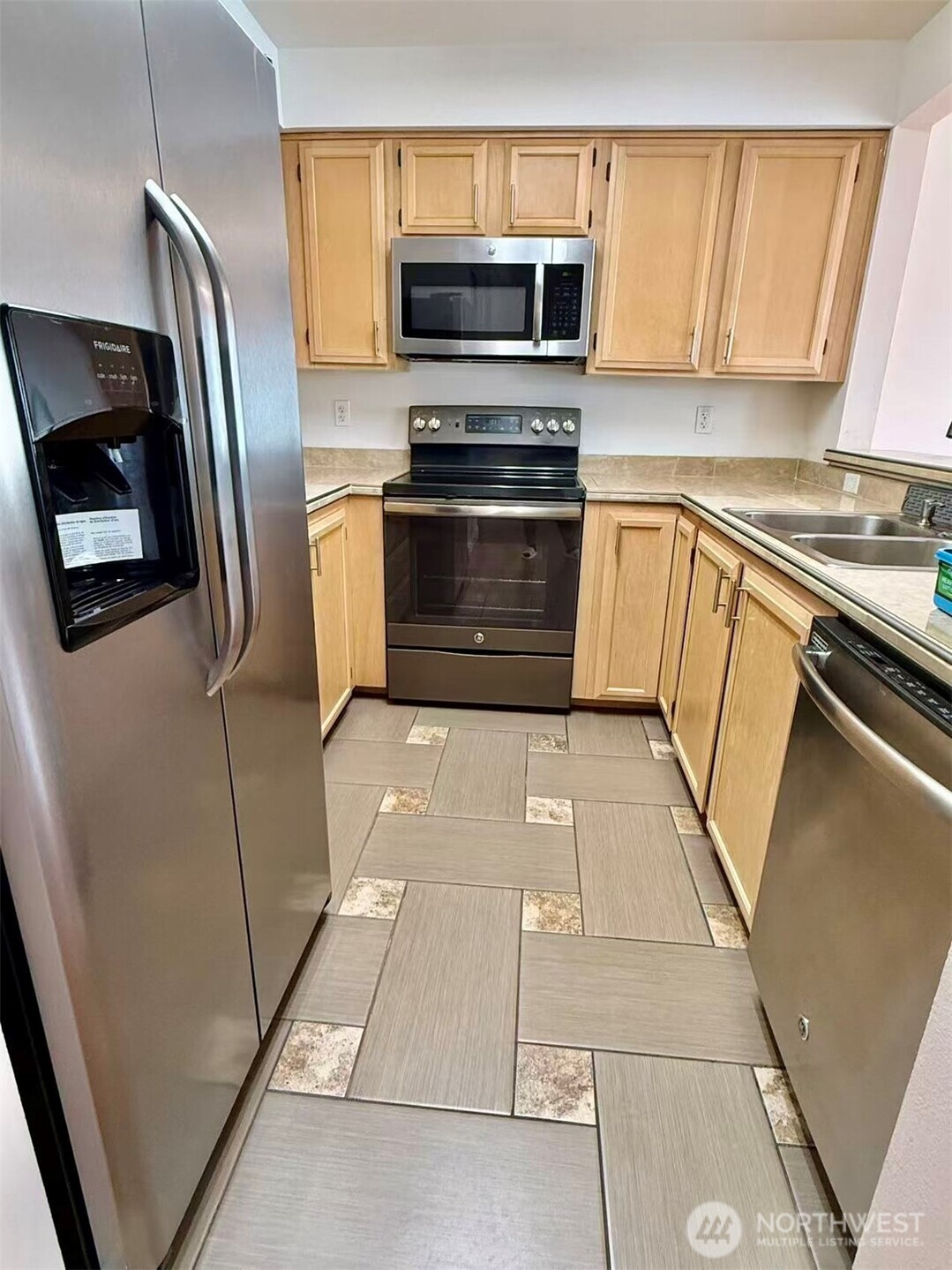 927 132nd Street Southwest, Unit D3 Everett, WA 98204 - Photo 5 of 20 a kitchen with granite countertop a refrigerator and a stove top oven