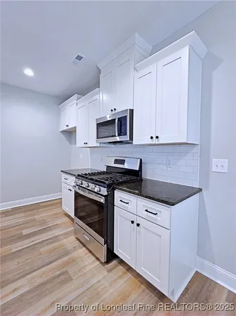 a bathroom with a granite countertop toilet sink and mirror