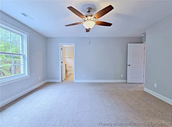 a view of an empty room with sliding door and wooden floor