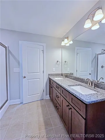 a bathroom with a glass shower door and a sink