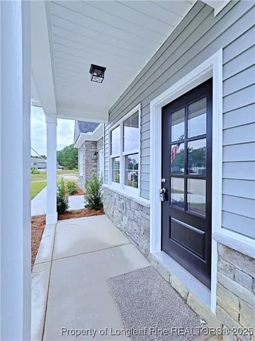 a view of an empty room with wooden floor and window