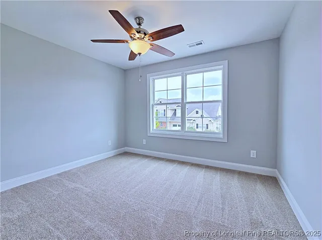 an empty room with closet and a ceiling fan