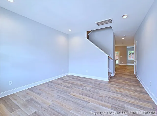 a view of empty room with wooden floor and fireplace