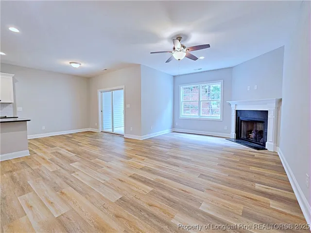 an empty room with wooden floor and a ceiling fan