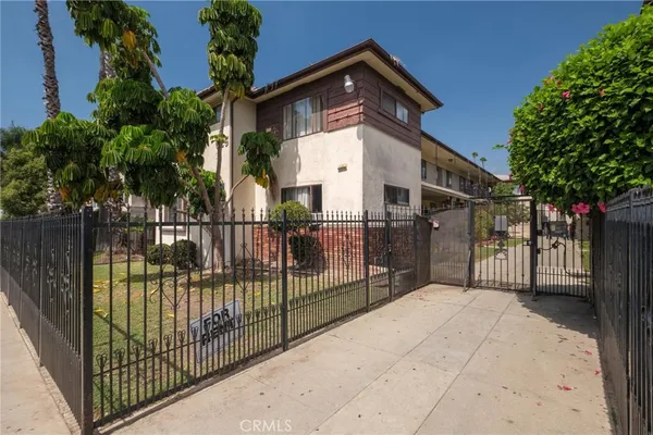 a view of a house with a small yard and wooden fence