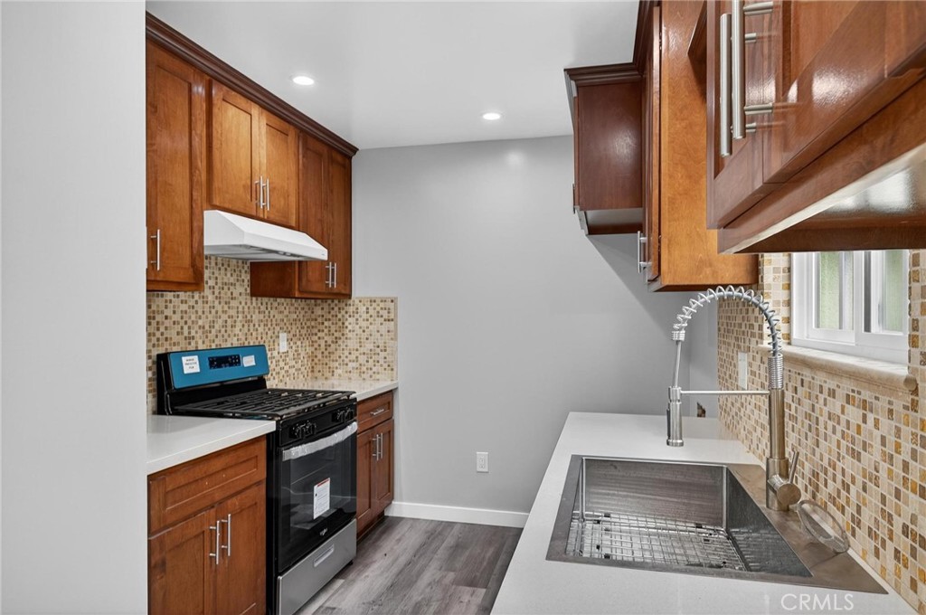 625 East 99th Street Inglewood, CA 90301 - Photo 30 of 50 a kitchen with stainless steel appliances granite countertop a stove a sink and a microwave