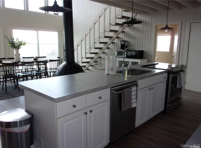 a kitchen with kitchen island granite countertop a sink and a stove