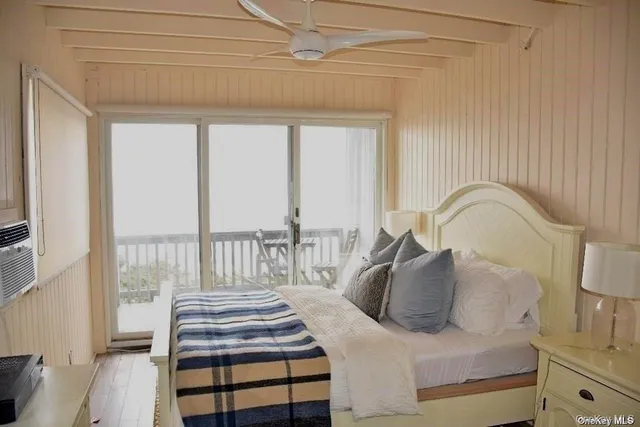 a bedroom with a bed and a large window with the outer view