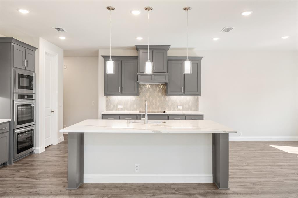 4410 Biscayne Drive Midlothian, TX 76065 - Photo 15 of 40 a view of a kitchen with kitchen island a counter top space stainless steel appliances and cabinets