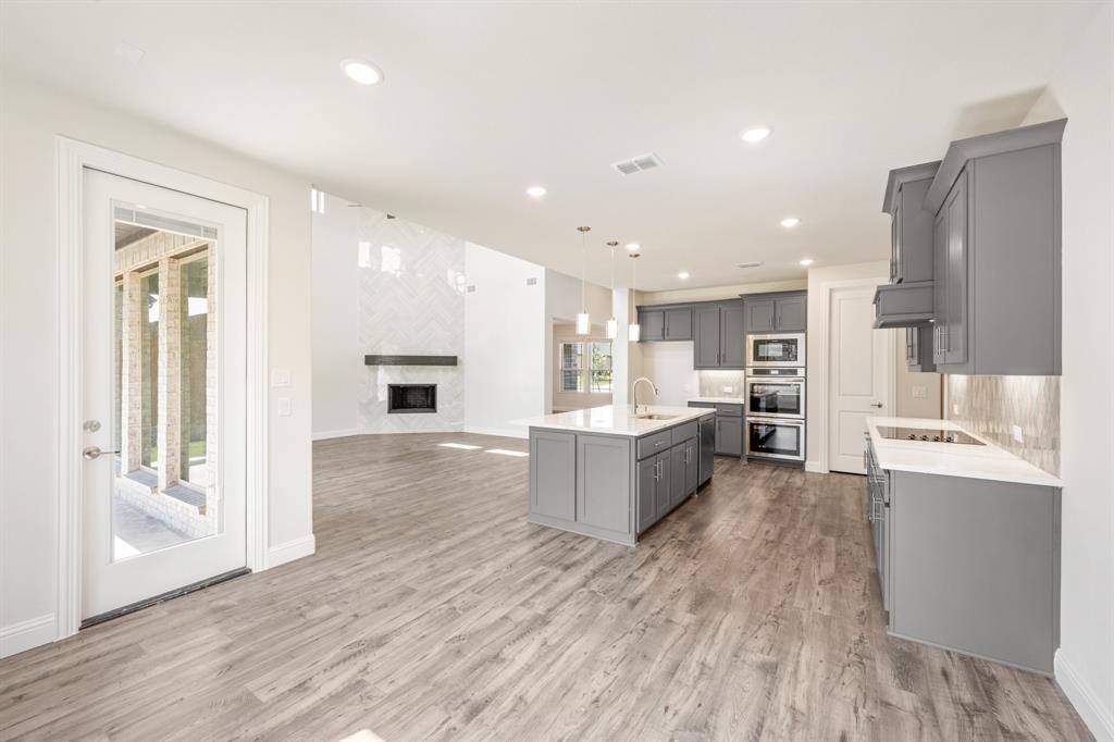 4410 Biscayne Drive Midlothian, TX 76065 - Photo 17 of 40 a large kitchen with a large counter top a sink stainless steel appliances and cabinets