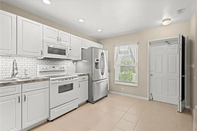 a kitchen with stainless steel appliances granite countertop a refrigerator sink and stove