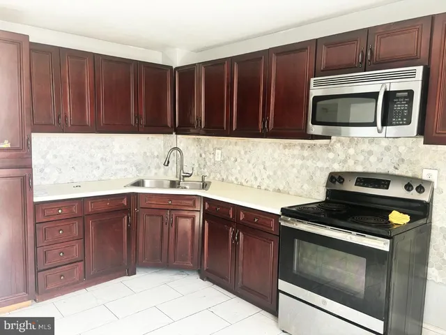 a kitchen with stainless steel appliances granite countertop a stove a microwave and a sink