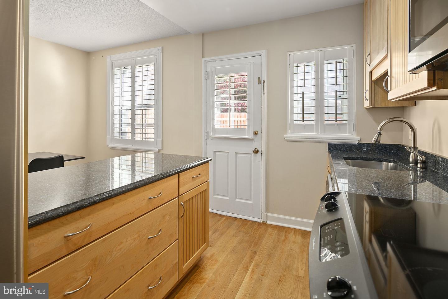 4634 31st Road South Arlington, VA 22206 - Photo 8 of 36 a kitchen with granite countertop a sink a stove and cabinets