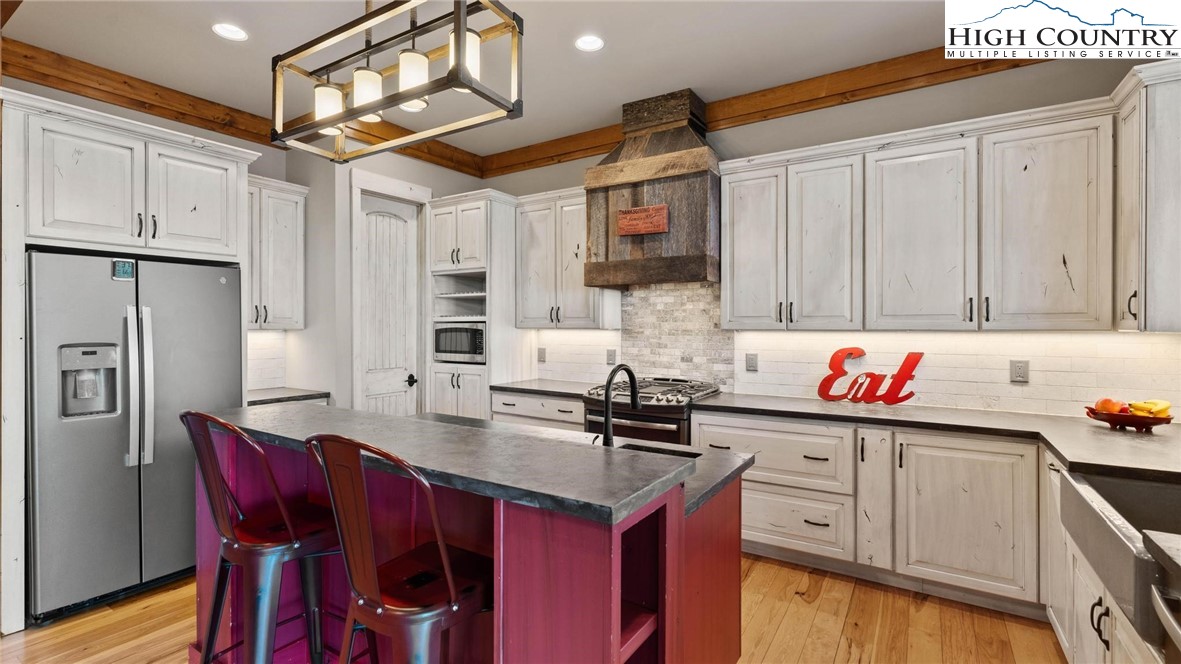 137 Burningbush Trail Boone, NC 28607 - Photo 15 of 50 a kitchen with stainless steel appliances kitchen island granite countertop a table chairs in it and wooden floors