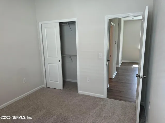 an empty room with an entryway and closet