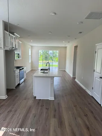 a kitchen with stainless steel appliances granite countertop a refrigerator a stove top oven a sink dishwasher and wooden floor