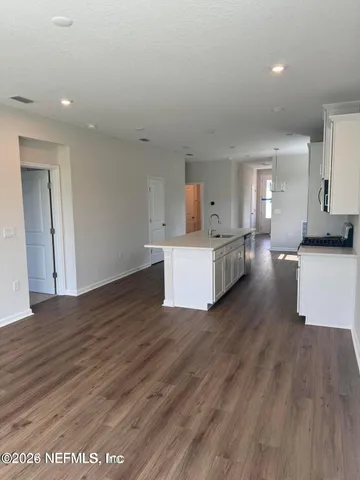 a view of a kitchen with wooden floor and a sink
