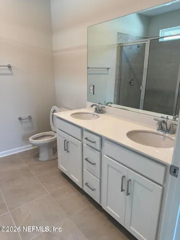 a bathroom with a granite countertop sink a toilet and a mirror